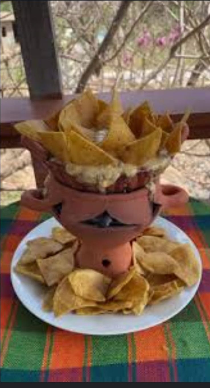 Un bol de patatas fritas está encima de un plato sobre una mesa.