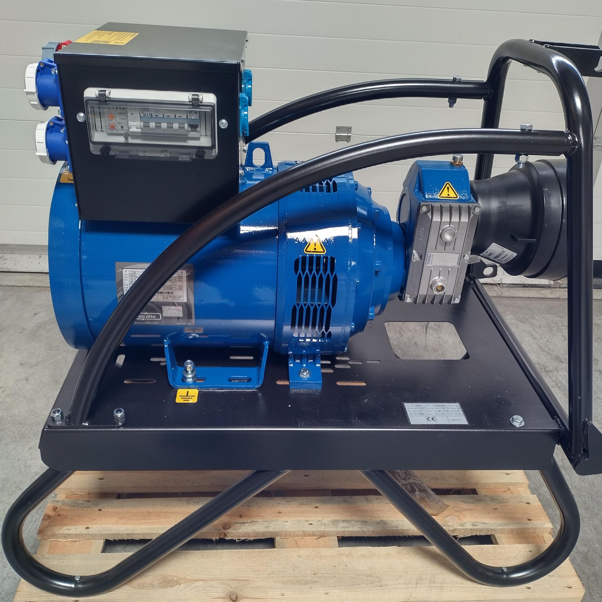 Générateur bleu avec châssis noir, panneau électrique et prises, posé sur une palette.