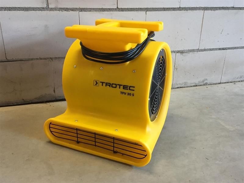 Ein gelber Trotec-Ventilator sitzt auf dem Boden