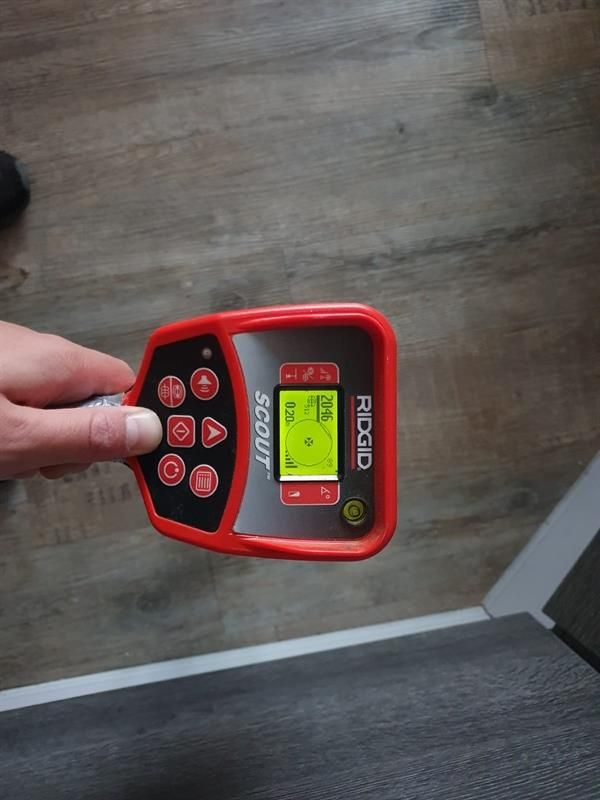 Eine Person hält ein Gerät mit der Aufschrift „Ridgid“