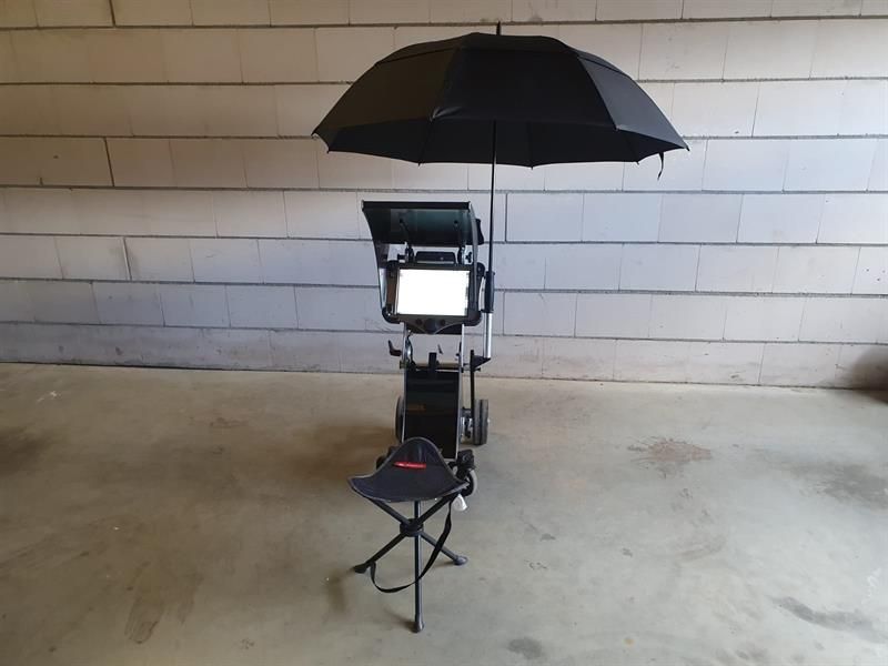 Ein schwarzer Regenschirm liegt auf einem Stuhl