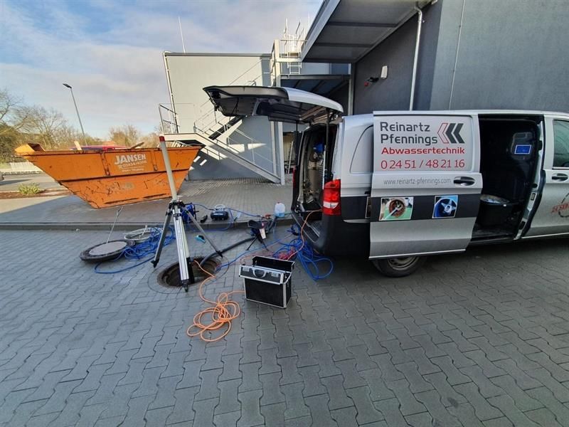 Ein Lieferwagen steht mit offener Tür vor einem Gebäude