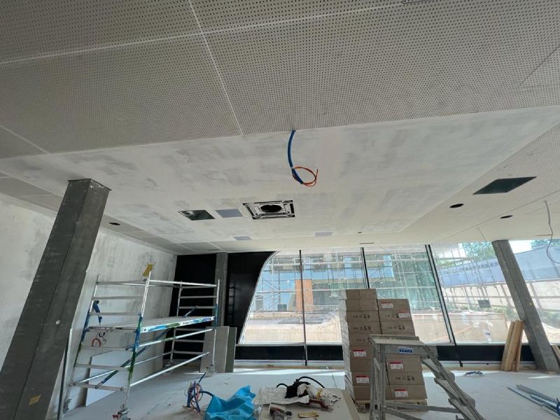 Eine Frau sitzt auf einer Couch und telefoniert mit einem Mobiltelefon.