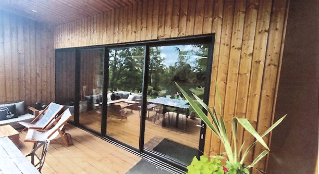 Baie vitrée noir entouré d'une façade en bois