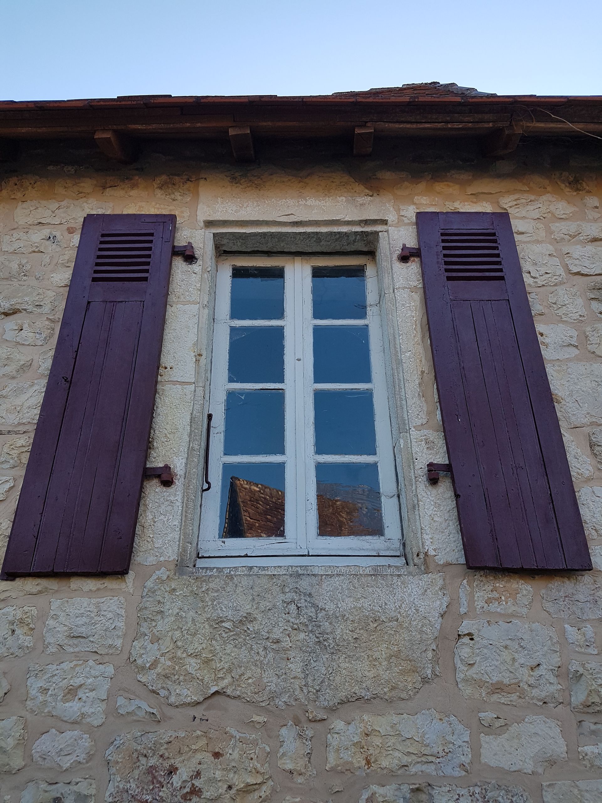 Fenêtre en bois avec des volets rouges