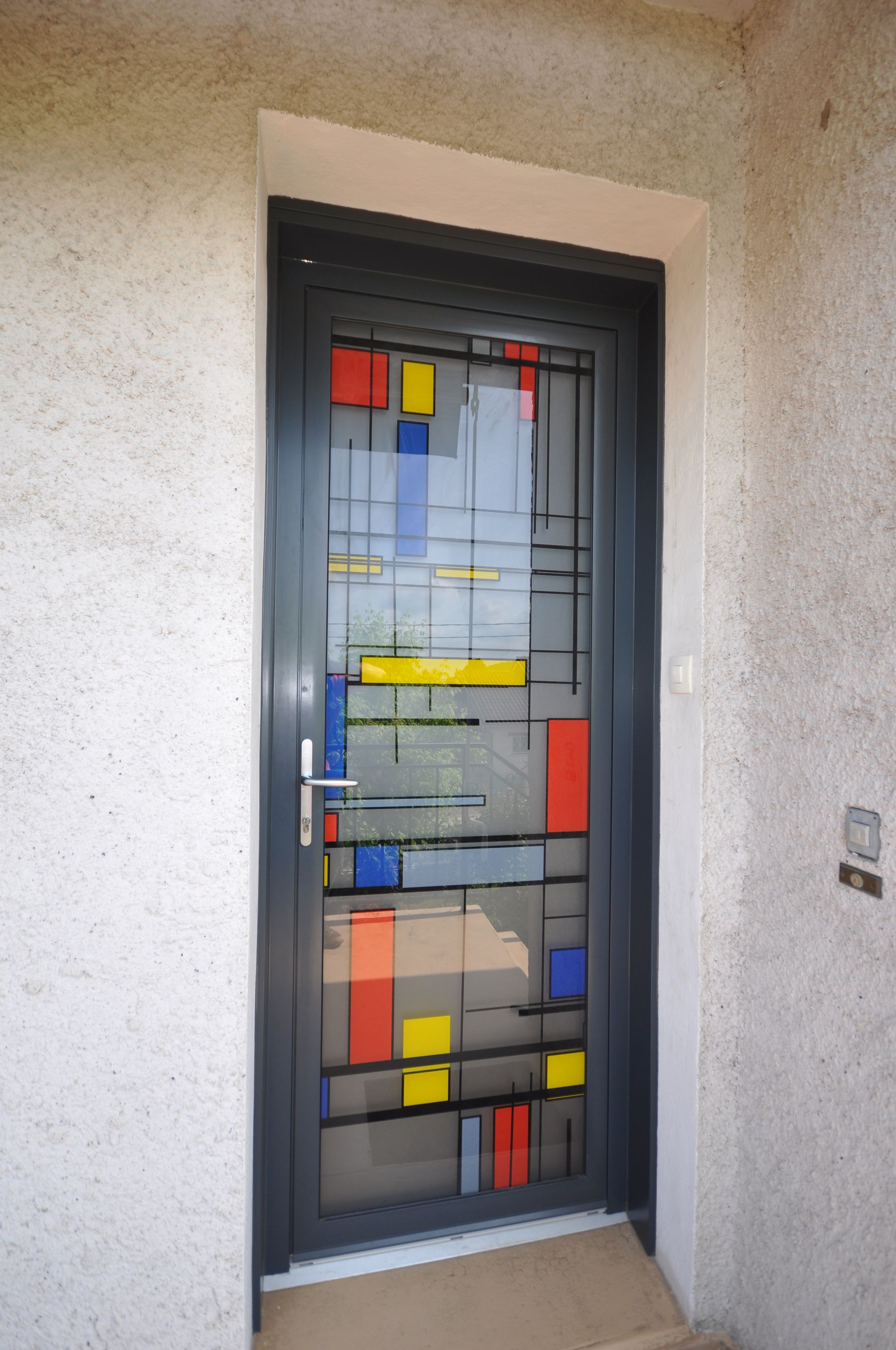 Porte en alu avec des carreaux colorés
