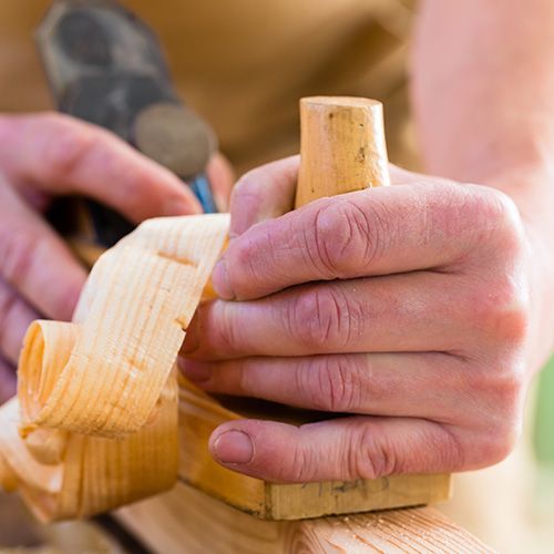 homme qui rabote le bois
