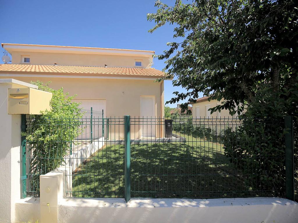 Clôture en grillage vert et transparent devant jardin vert - agrandissement