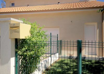 Clôture en grillage vert devant entrée d'immeuble - réalisations