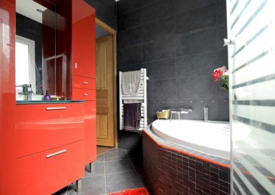 Salle de bain noir et rouge avec piscine en coin et sèche-serviette - réalisations