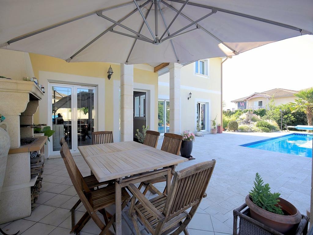 Terrasse avec barbecue en pierre, table et chaise en bois et piscine - dallage