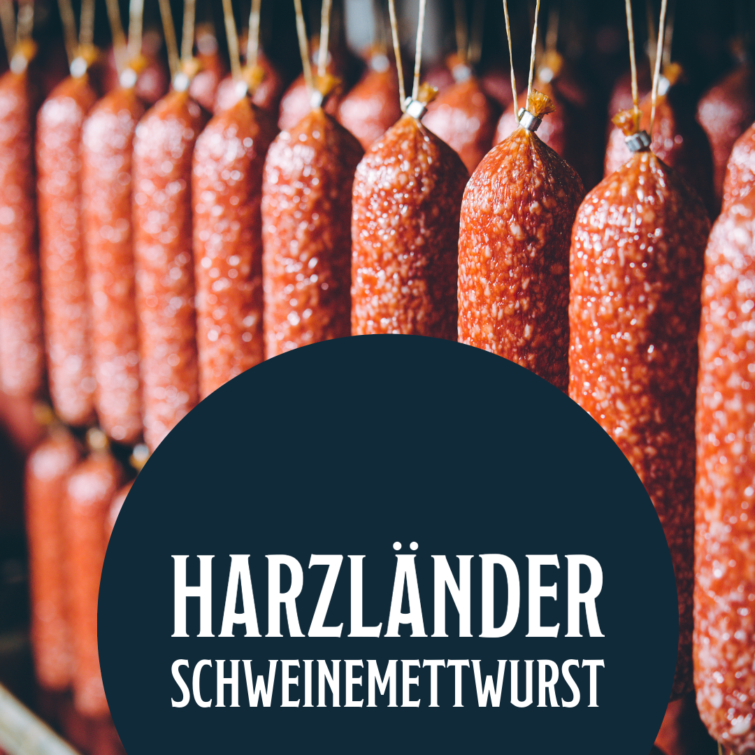 Reihen von hängenden Würsten mit einem dunklen Etikett mit der Aufschrift „HARZLÄNDER SCHWEINEMETTWURST“