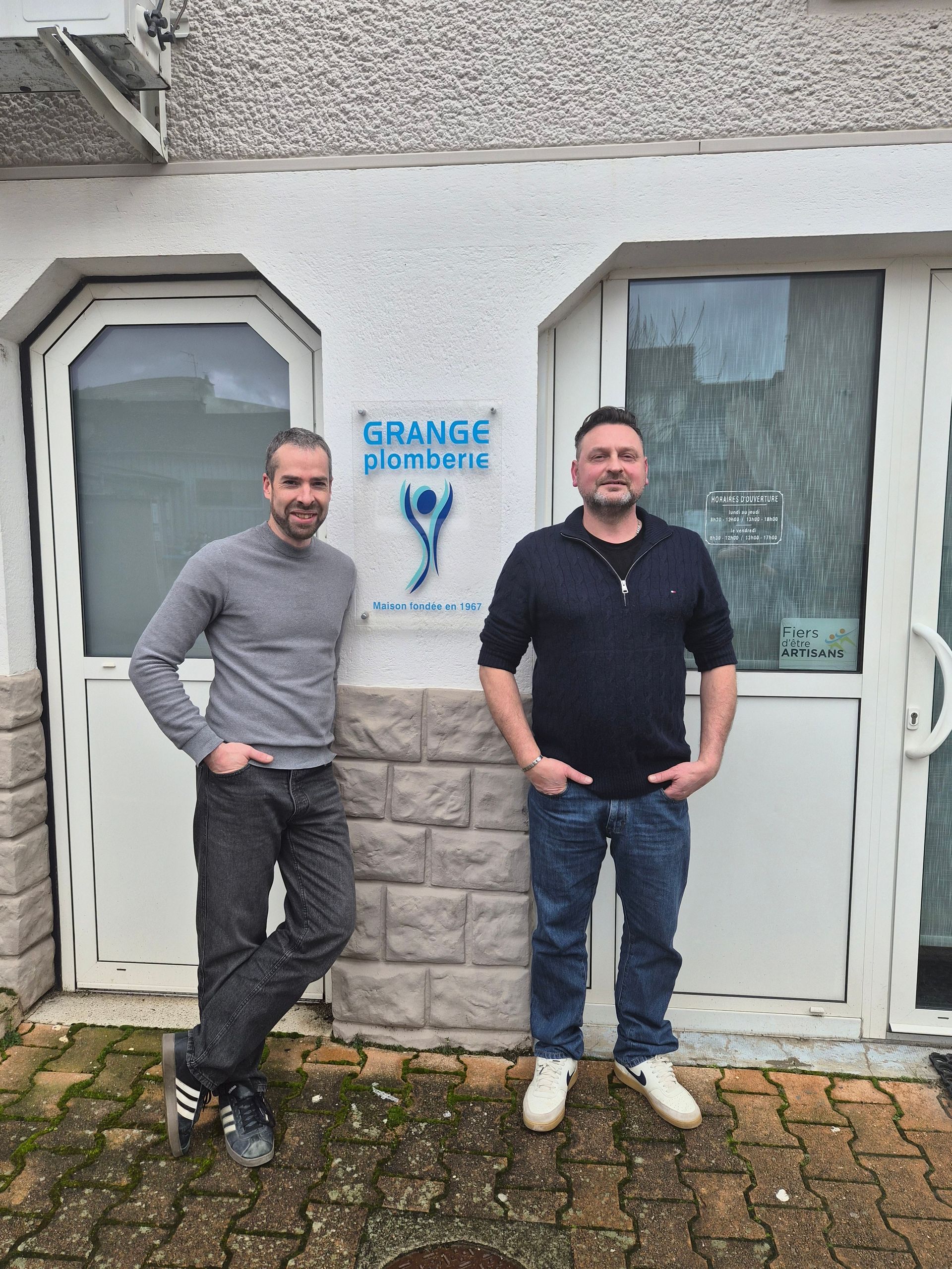 Homme à tout faire avec une ceinture à outils, les bras croisés, souriant.