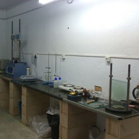 Un laboratorio con una mesa larga y mucho equipo sobre ella.