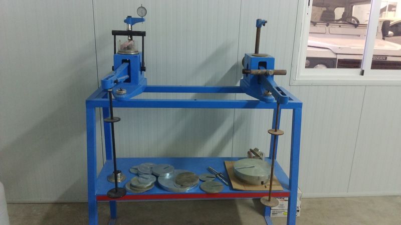 Una mesa azul con un montón de herramientas encima en una habitación.