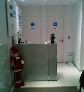 Una estatua de Papá Noel está de pie junto a un mostrador en un pasillo.