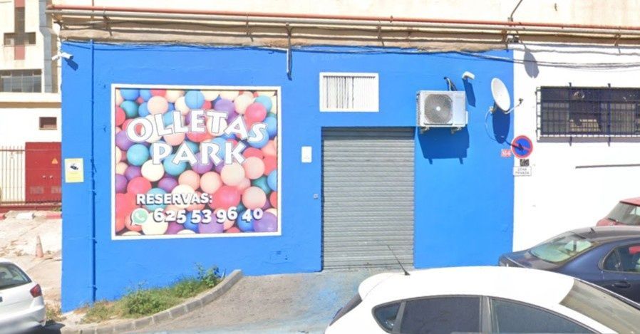 Fachada azul con un letrero rojo en la ventana que dice 