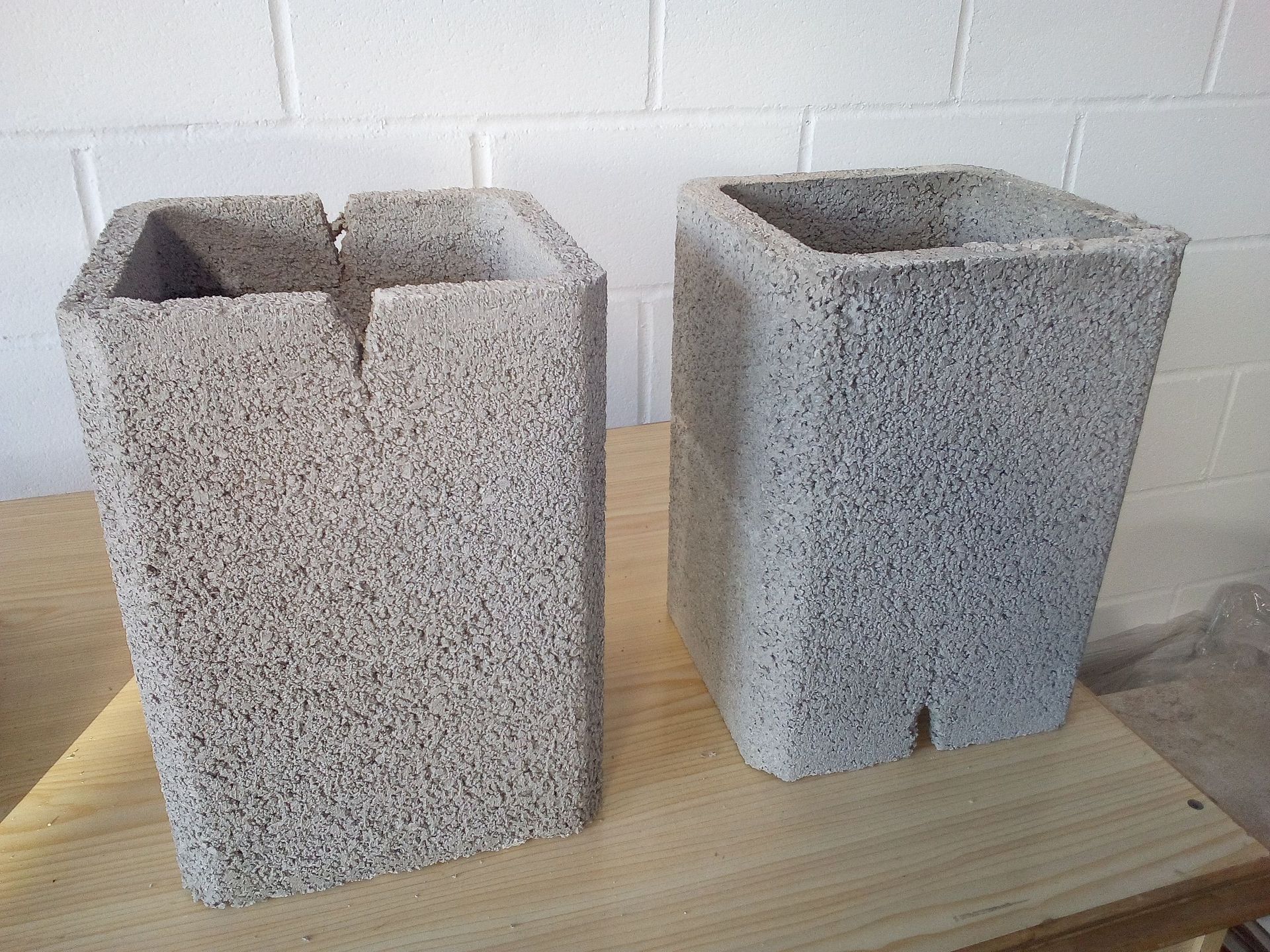 Dos bloques de hormigón están sobre una mesa de madera.