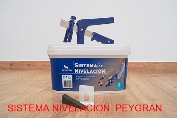 Un cubo del sistema de nivelación está sobre un piso de madera.