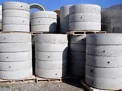 Un montón de anillos de hormigón apilados uno encima del otro sobre paletas.