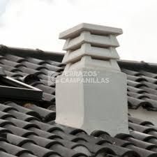 Una chimenea está situada encima de un techo de tejas.