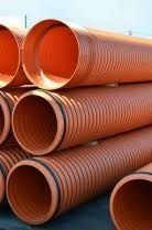 Una pila de tubos de plástico de color naranja apilados uno encima del otro.