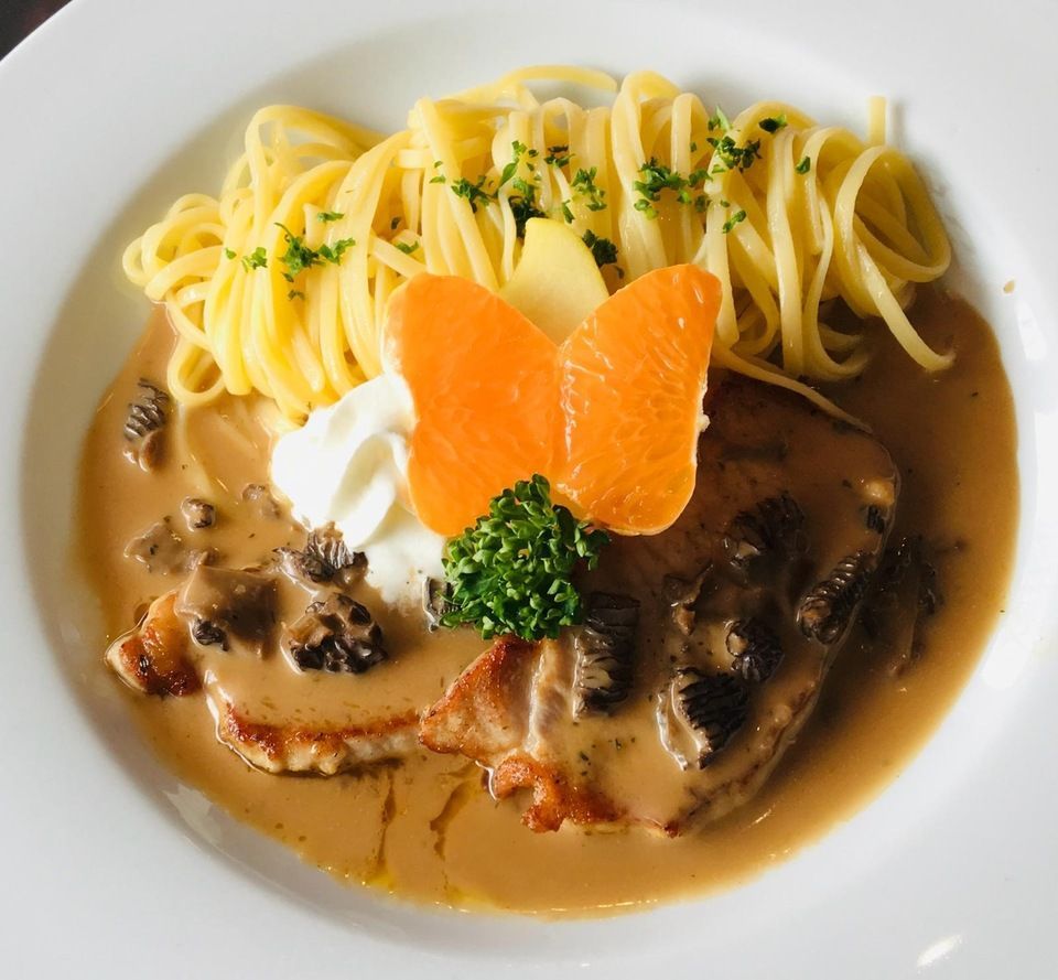 Eine Nahaufnahme von einem Teller mit Essen mit Nudeln und Soße