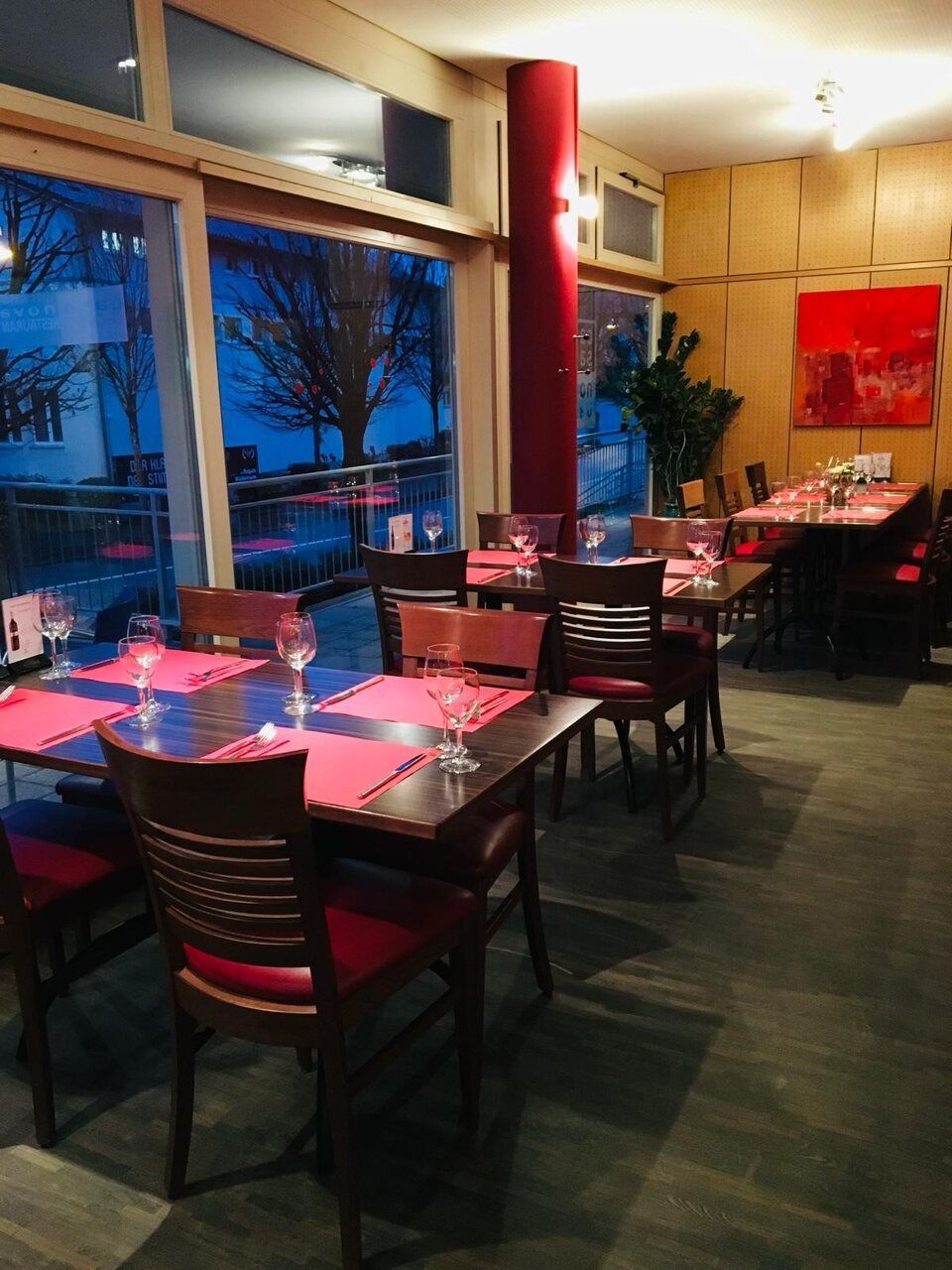 Ein Restaurant mit Tischen und Stühlen und einem großen Fenster