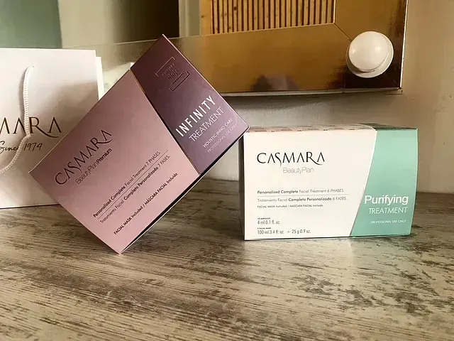 Dos cajas de cuidado de la piel Casmara sobre una superficie de madera. Una morada, con la etiqueta