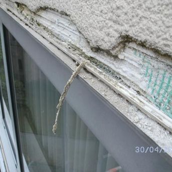 schadhafte Stelle in der Fassade über einem Fenster