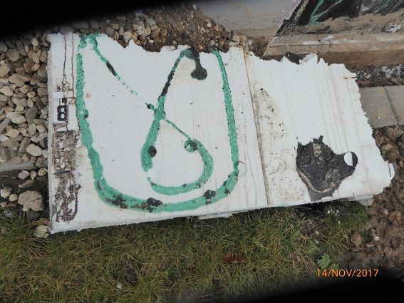 Stück aus einer Wand entfernt und zeigt auf dem Rasen