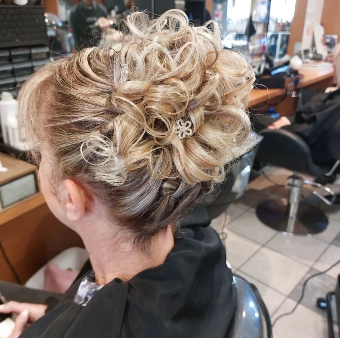 Chignon bouclé avec des barettes en forme de fleurs