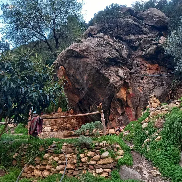 Una gran roca en medio de un exuberante campo verde.