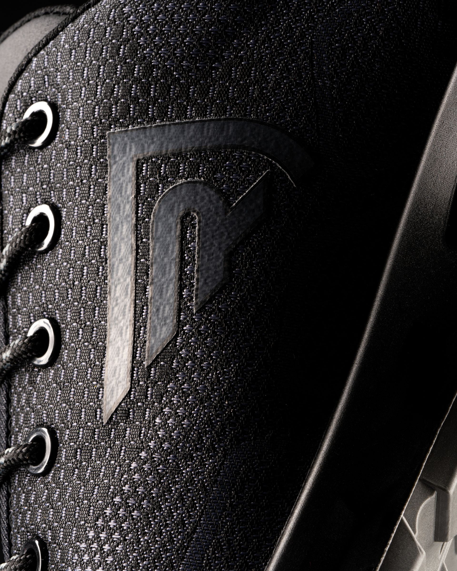 Un primer plano de un zapato negro con la letra p.