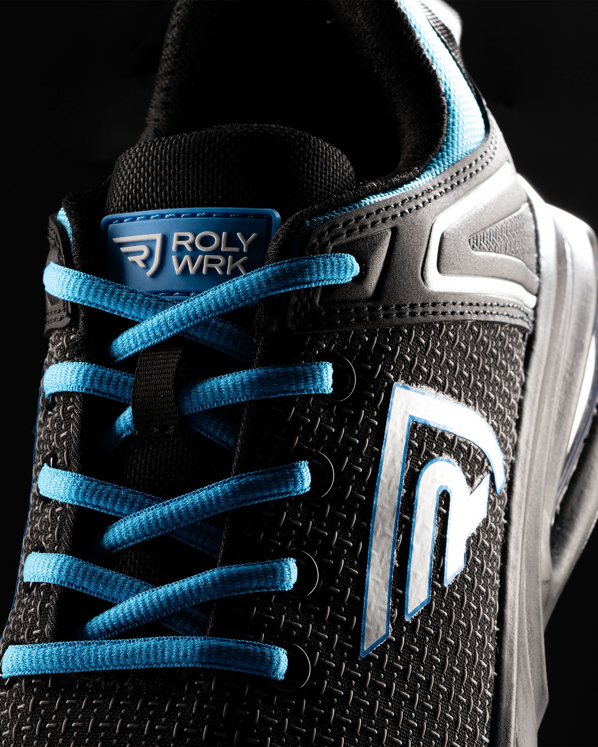 Un primer plano de un par de zapatos negros y azules que dicen Roly Wrk.