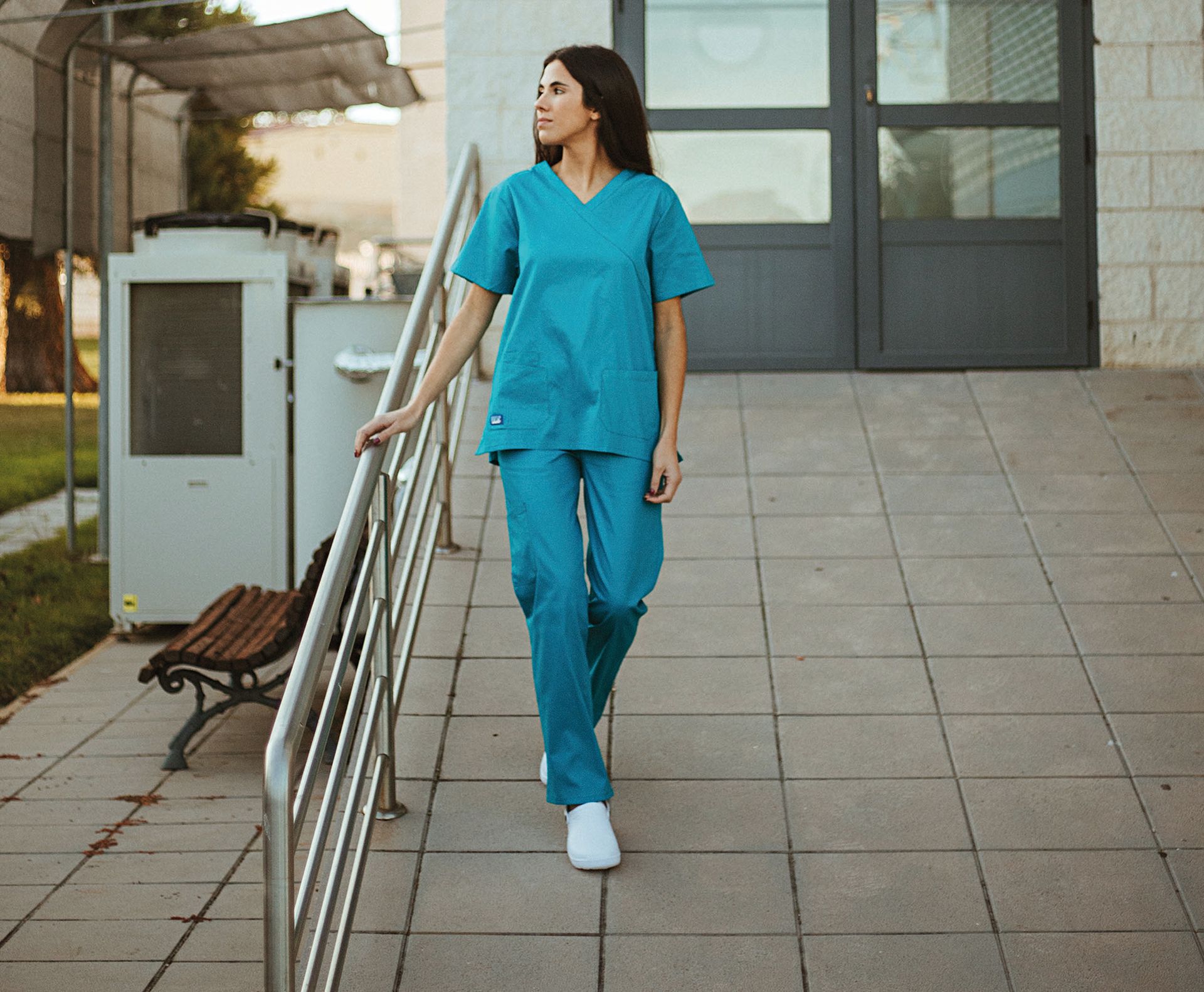 Una mujer con uniforme médico camina por una rampa.