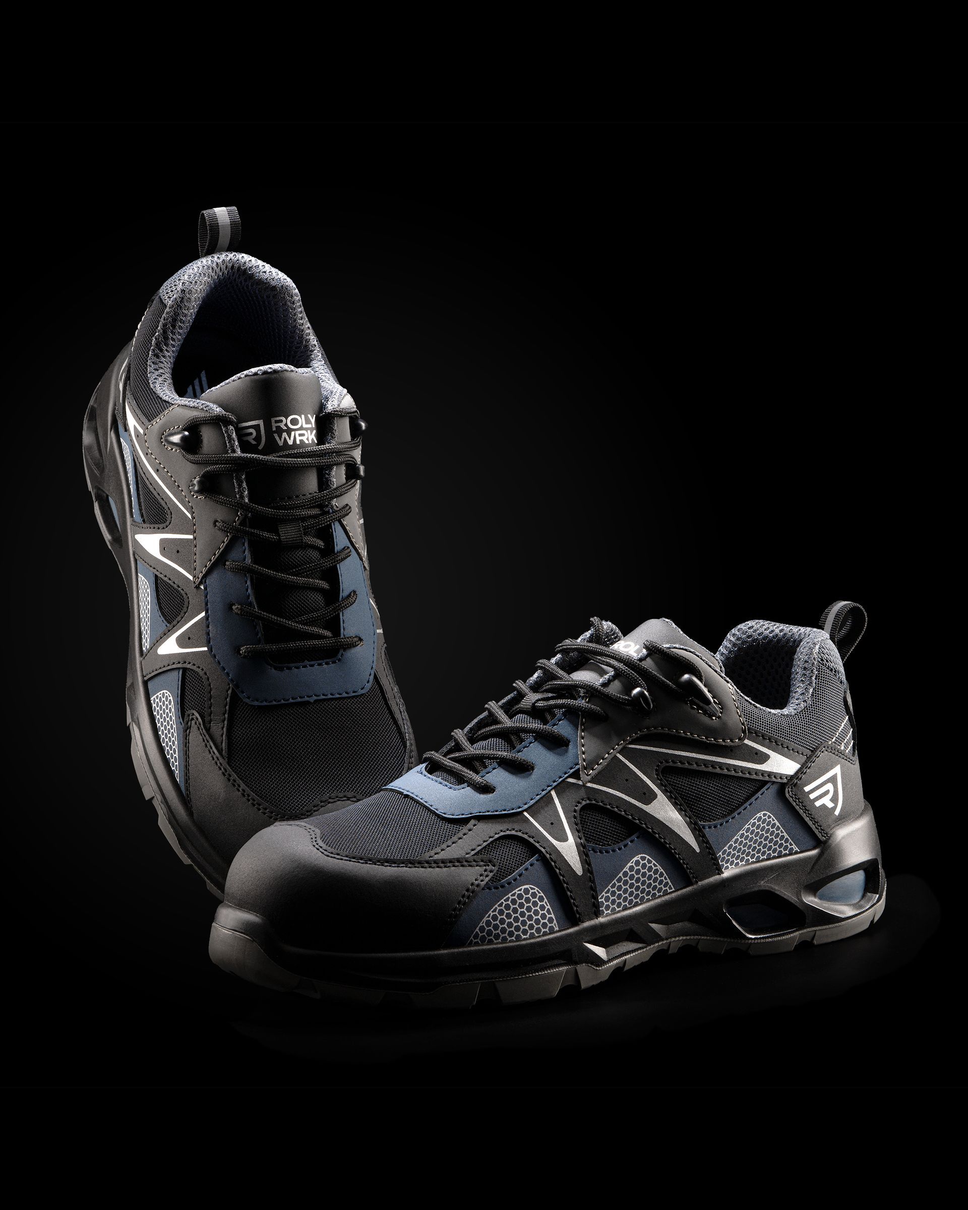 Un par de zapatillas negras y azules sobre un fondo negro.