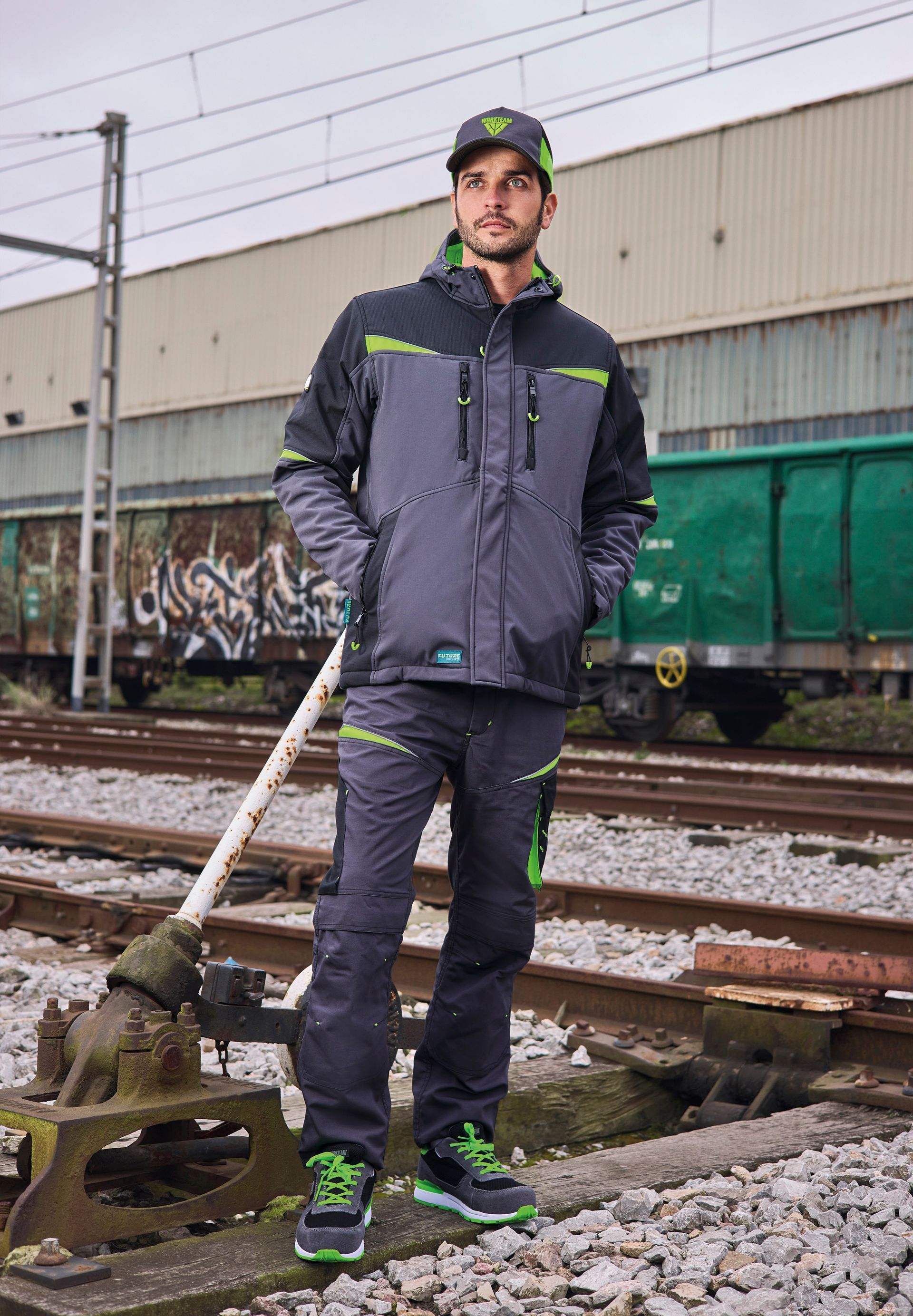 Un hombre está parado en una vía del tren sosteniendo una pala.