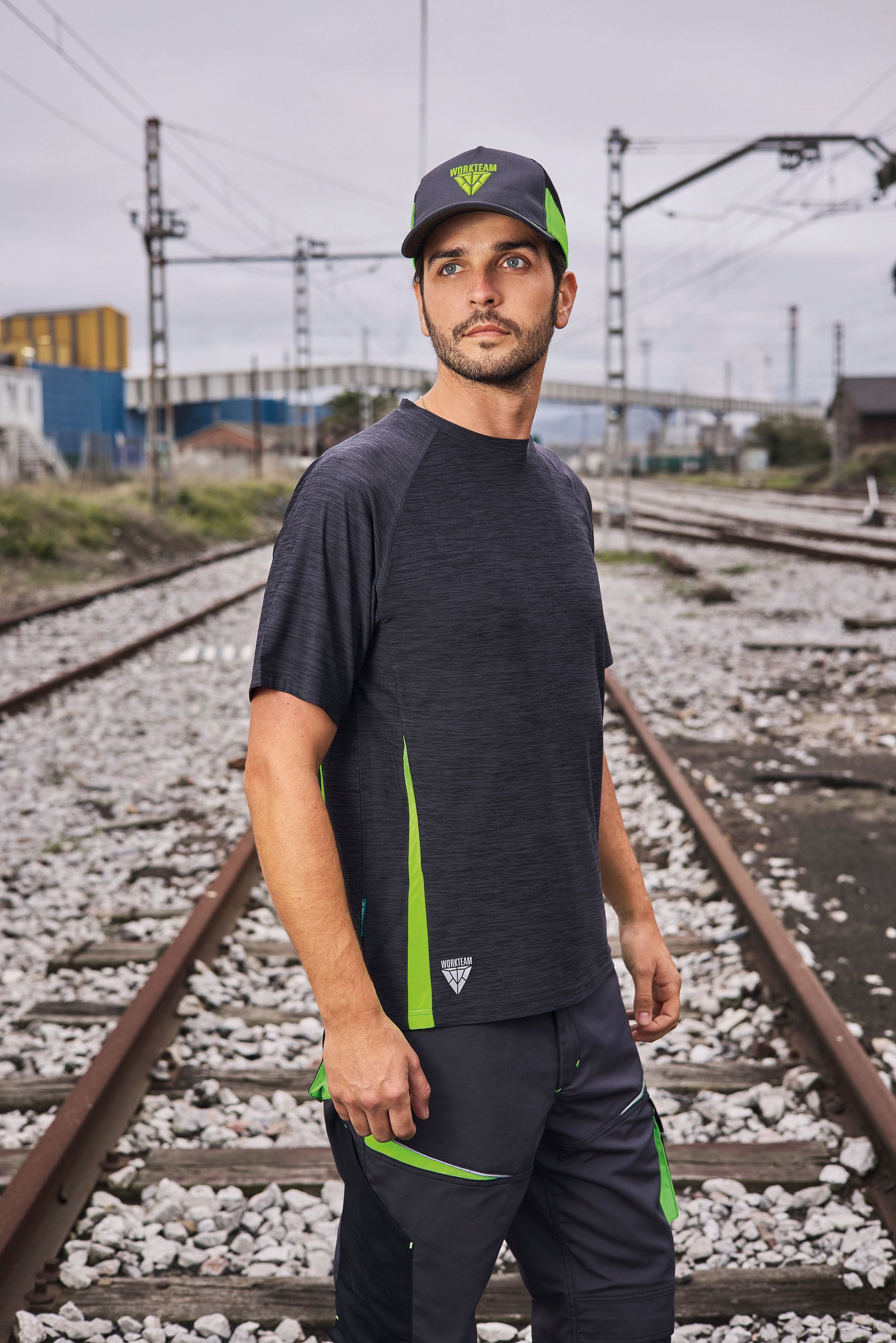 Un hombre con sombrero está parado sobre las vías del tren.