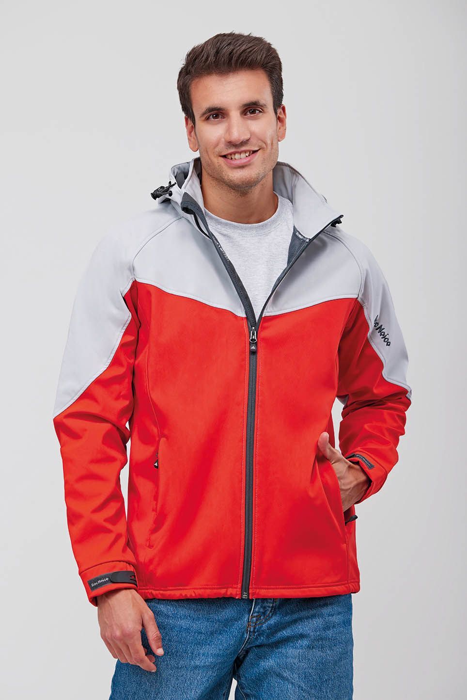 Un hombre lleva una chaqueta roja y gris con capucha.