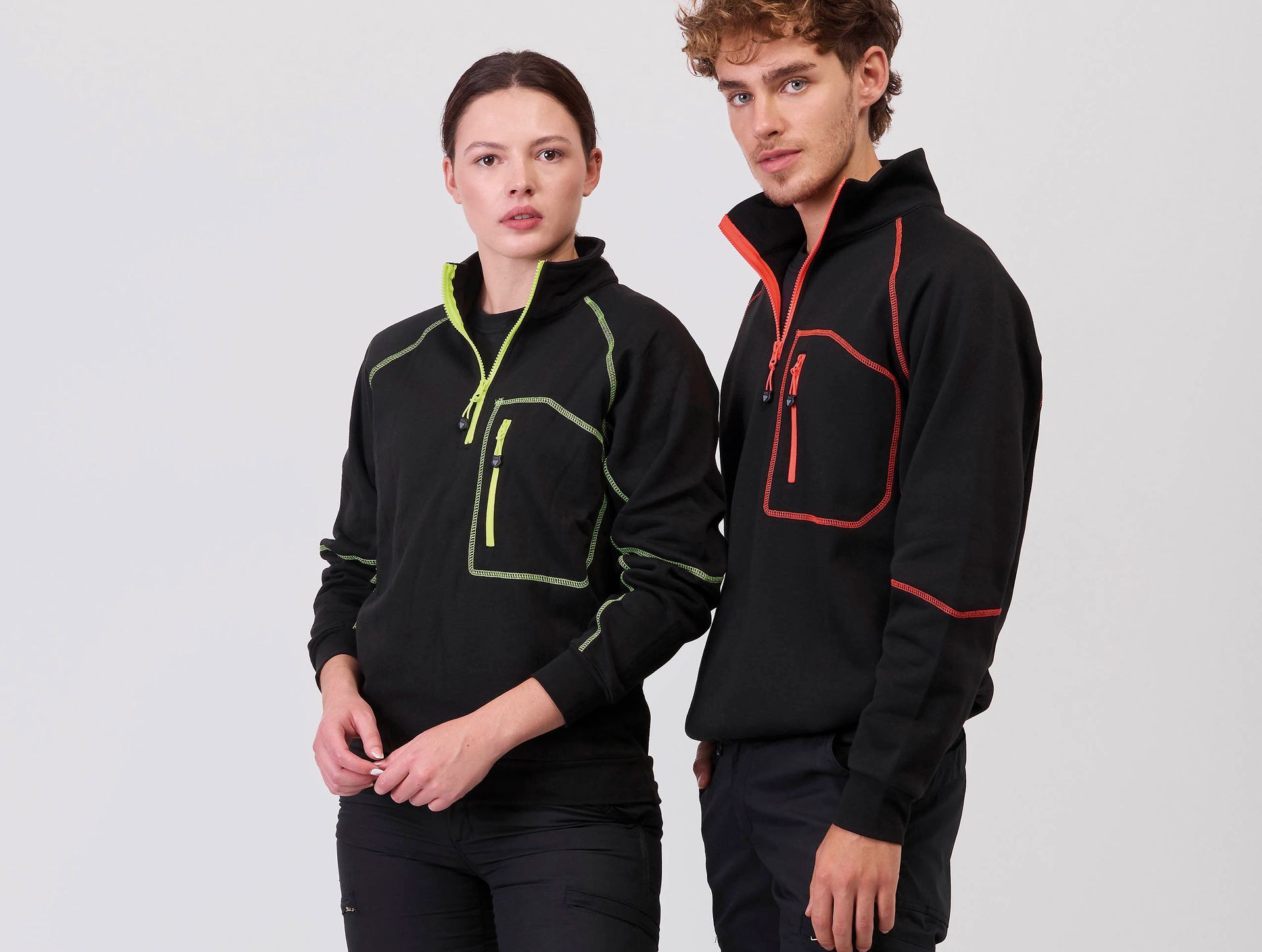 Un hombre y una mujer están parados uno al lado del otro vistiendo sudaderas negras.