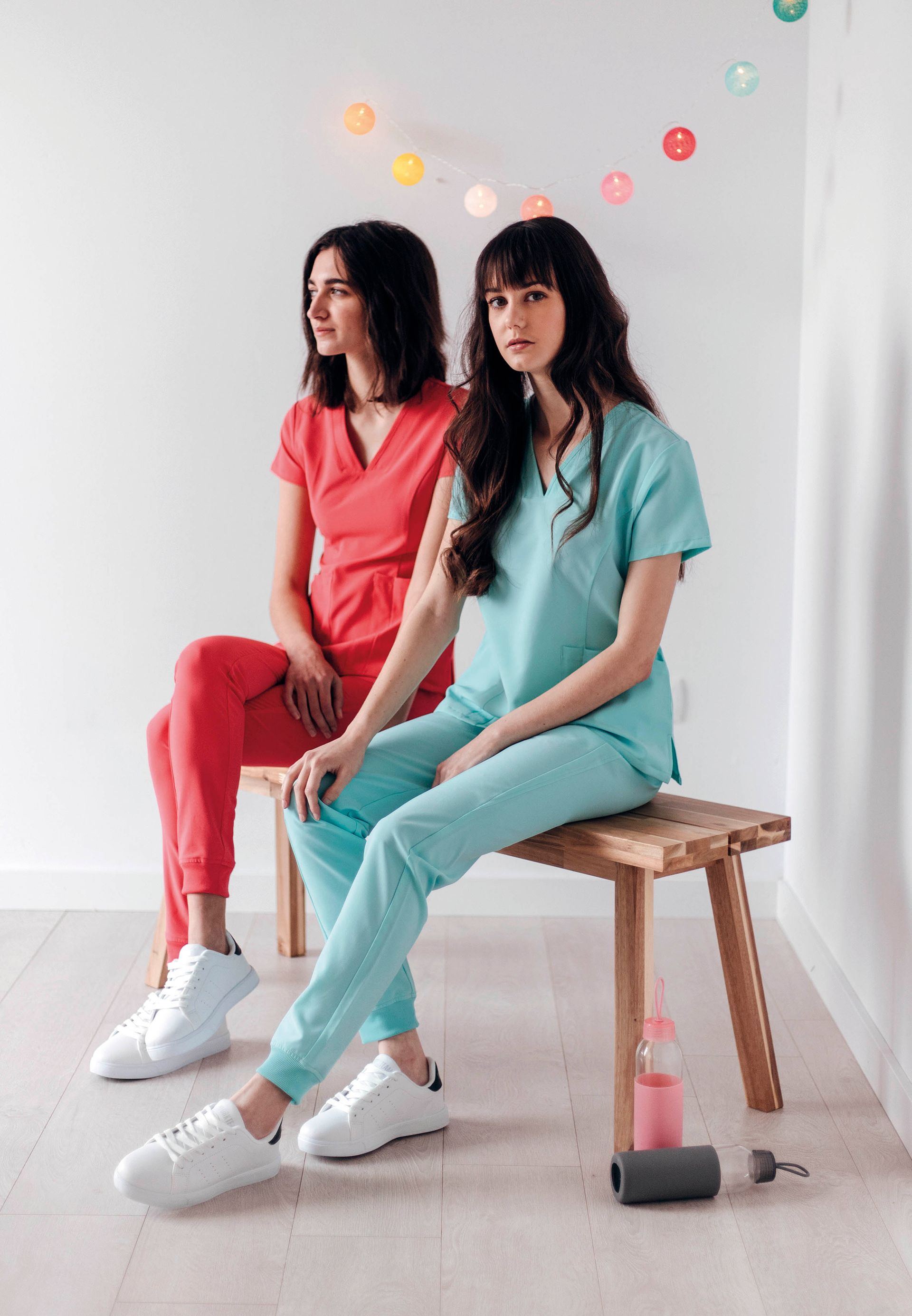 Dos mujeres con uniforme médico están sentadas en un banco.