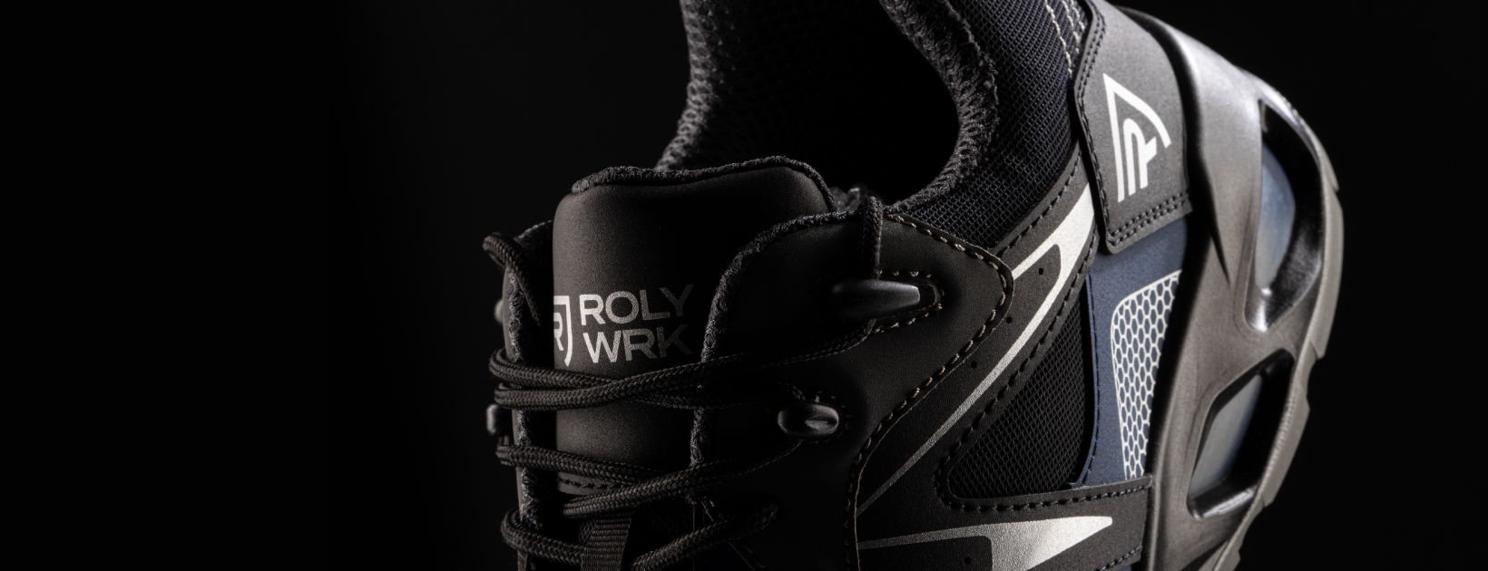 Un primer plano de un zapato negro sobre un fondo negro.