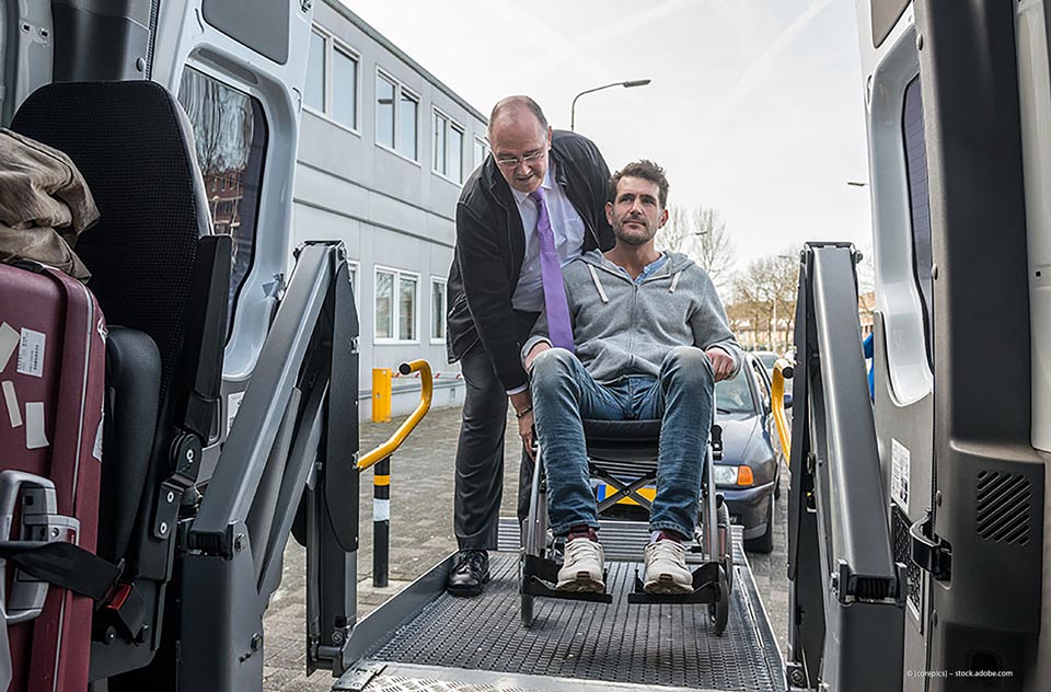 Taxi Tönnissen – Taxifahrer hilft einer Person im Rollstuhl ins Taxi