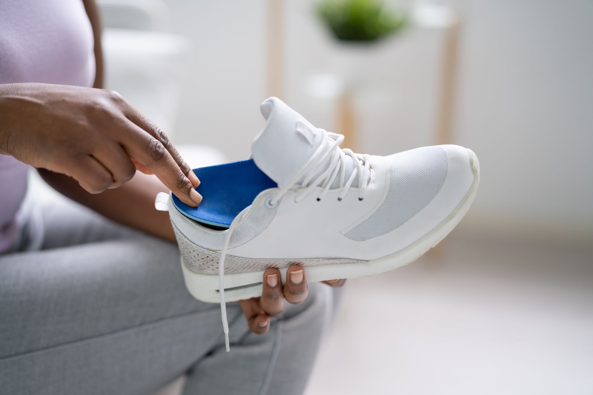 Une personne qui insère une semelle dans sa chaussure