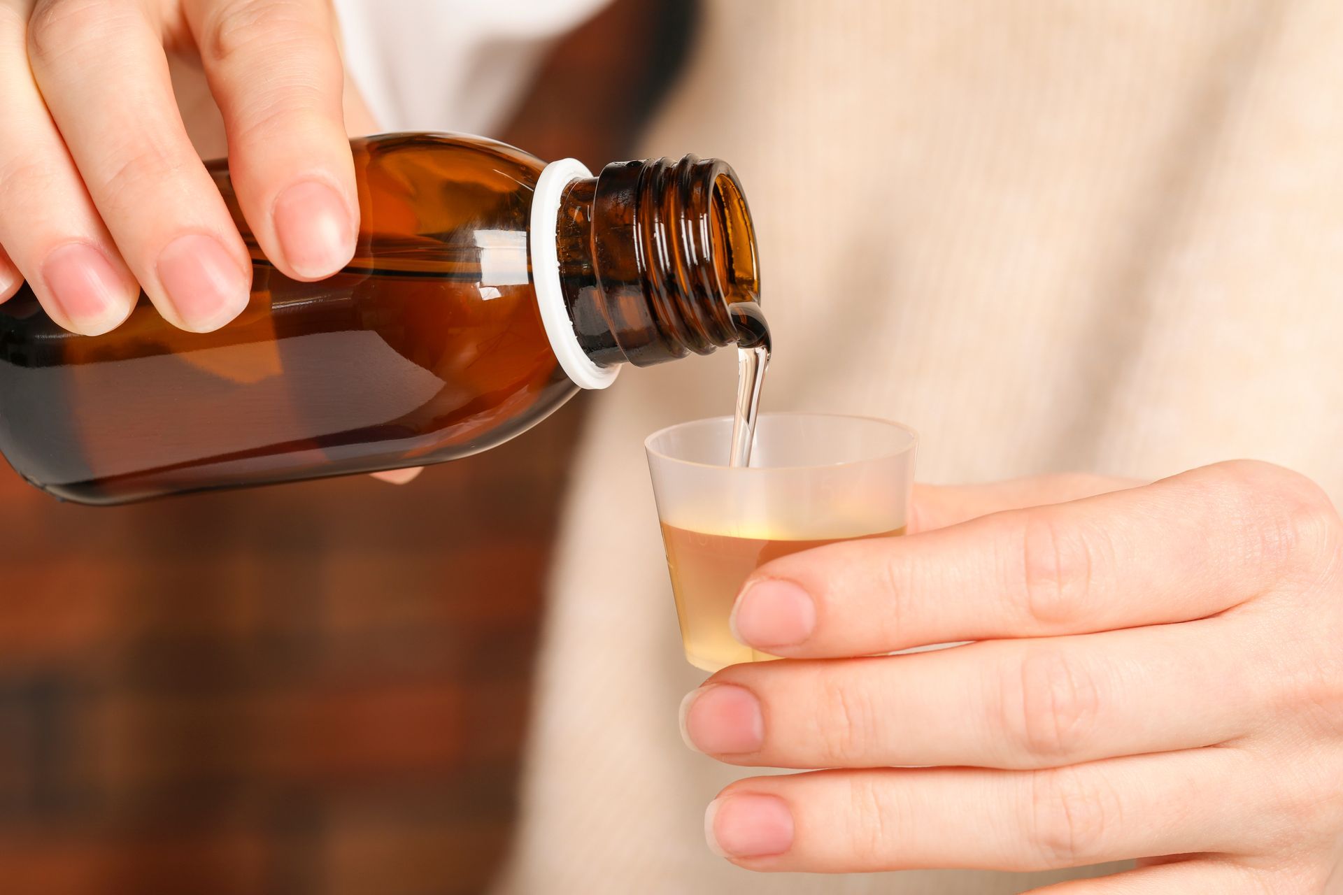 Une personne prenant un sirop homéopathique