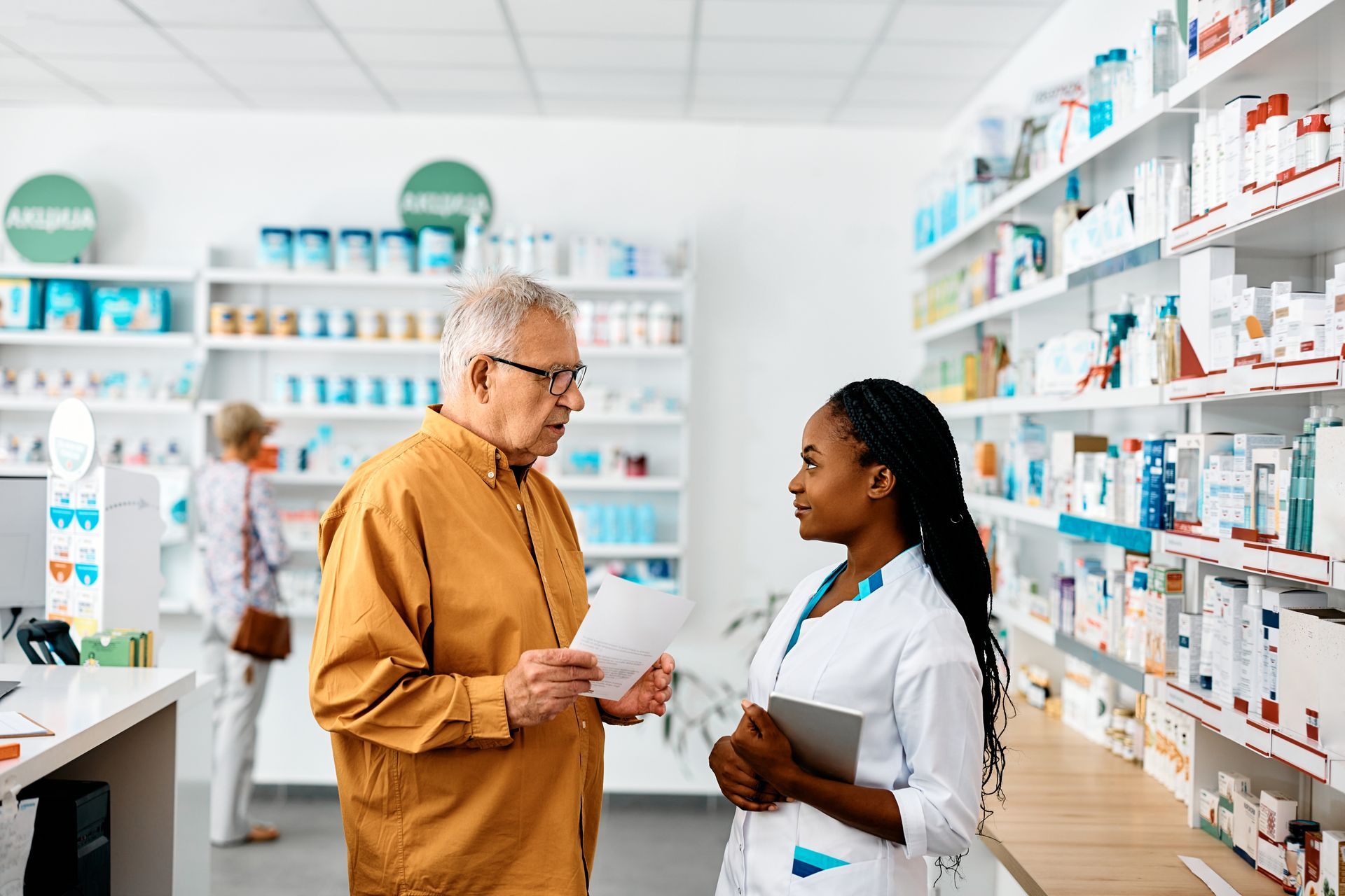 Un client qui demande conseil à une préparatrice en pharmacie