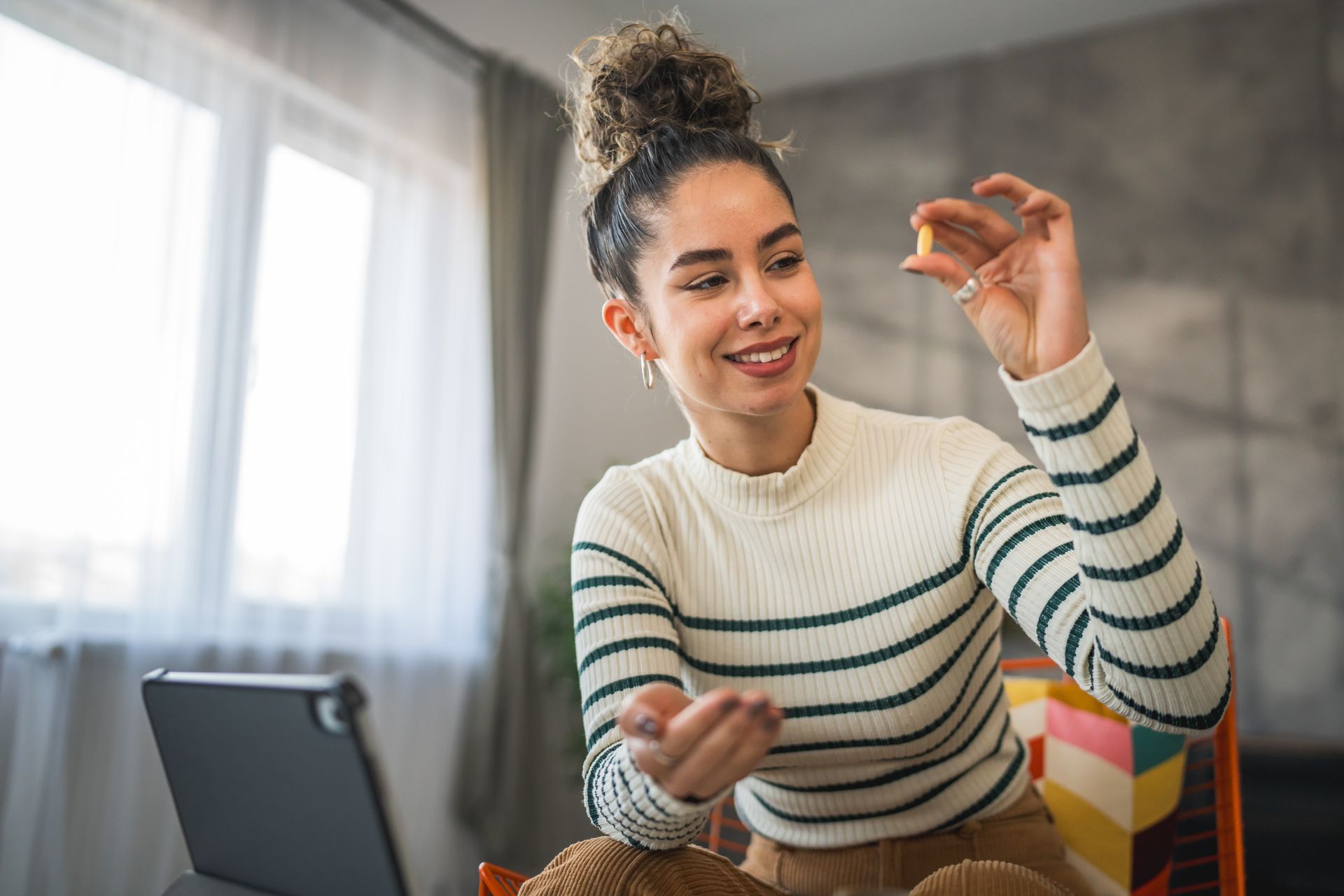 Une femme tenant un complément alimentaire dans la main