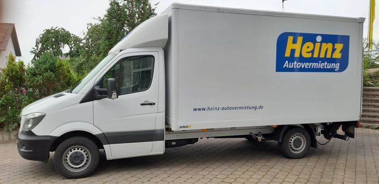 Fahrzeugmodelle Ein schwarzer SUV parkt auf einer gepflasterten Auffahrt vor einer weißen Mauer