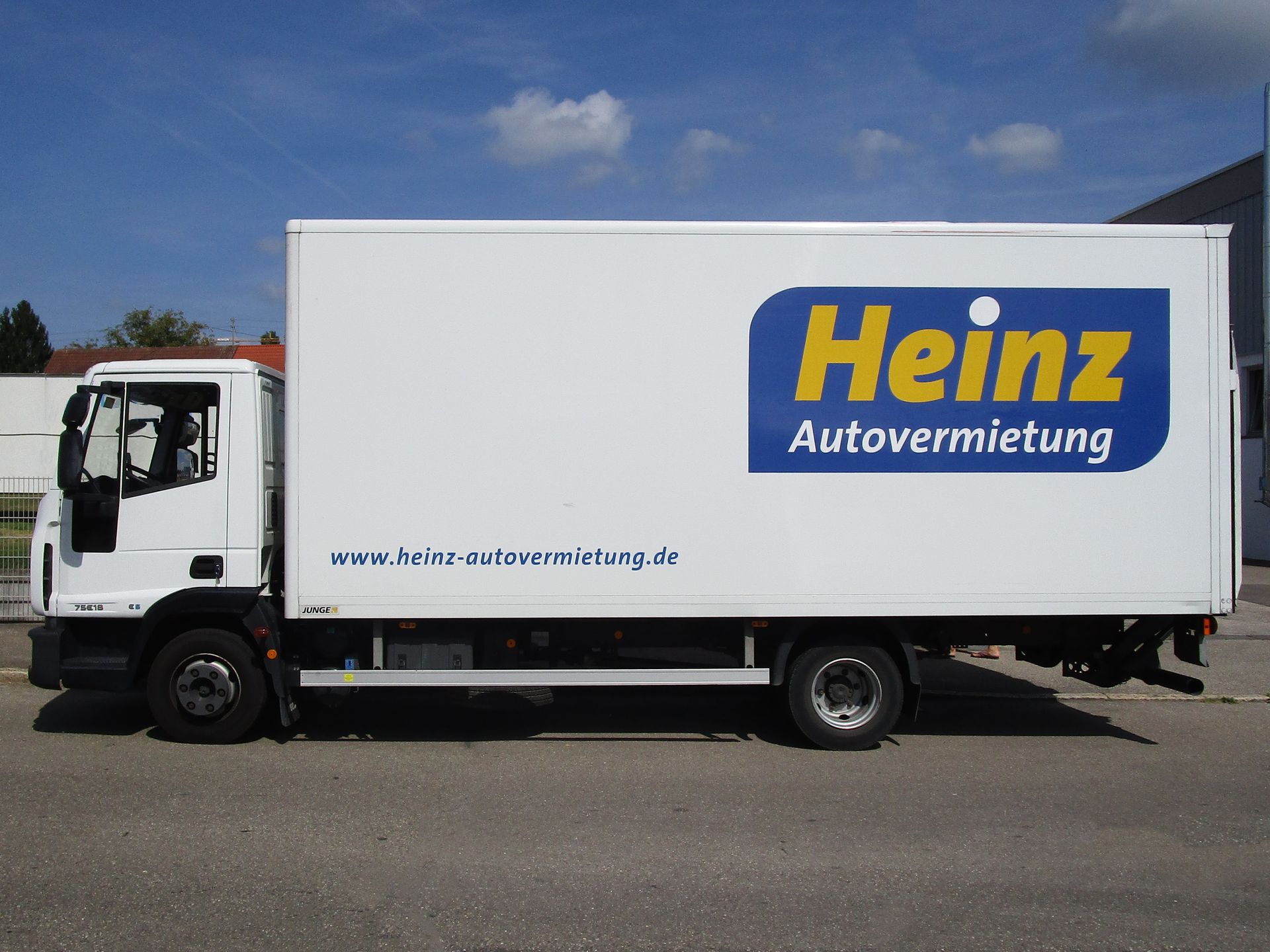Fahrzeugmodelle Eine schwarze Limousine parkte in einem hellen Ausstellungsraum mit großen Fenstern und Fliesenboden